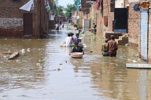 People wade through a flooded street