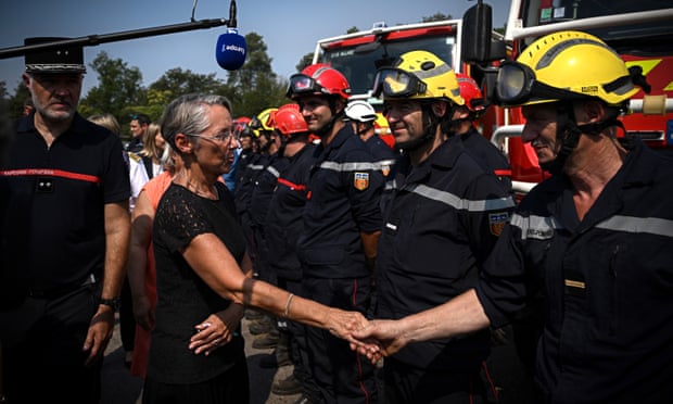 La première ministre française, Élisabeth Borne (au centre), salue les pompiers 