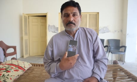Zafar Iqbal shows a picture of his son and other missing relatives