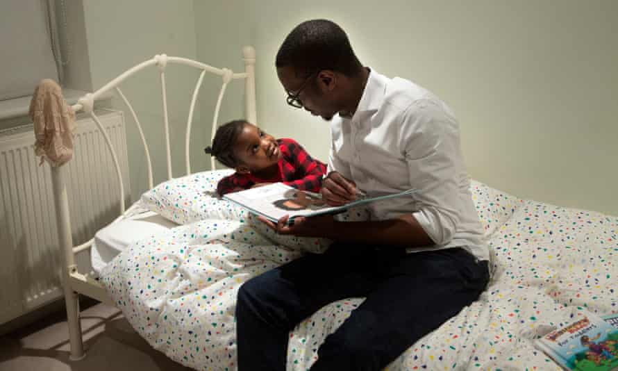 Robert reads a bedtime story with his daughter, Forefoluwa, 3, in their home in London