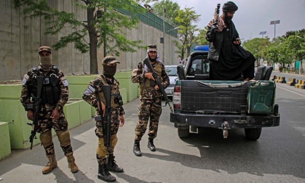 Taliban security stand guard in Sherpur following the drone strike.