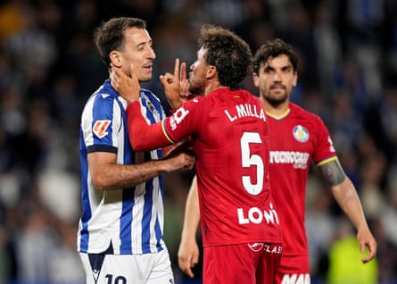 Mikel Oyarzabal of Real Sociedad and Luis Milla of Getafe argue with each other on the pitch