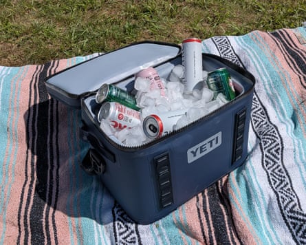 A Yeti Hopper Flip 18 cooler sitting on beach blanket in grass