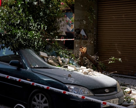 A fallen tree branch lies atop a damaged vehicle on a street in the aftermath of an earthquake that struck southern Spain, in Granada, Spain.
