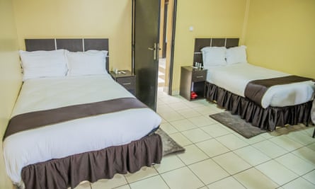 A room with two double beds and tiled floor