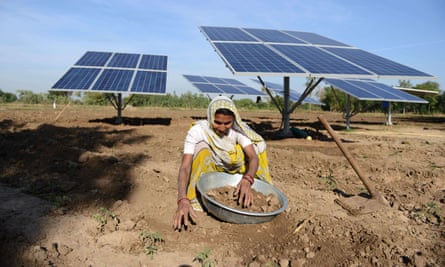 Woman in field with solar panels.