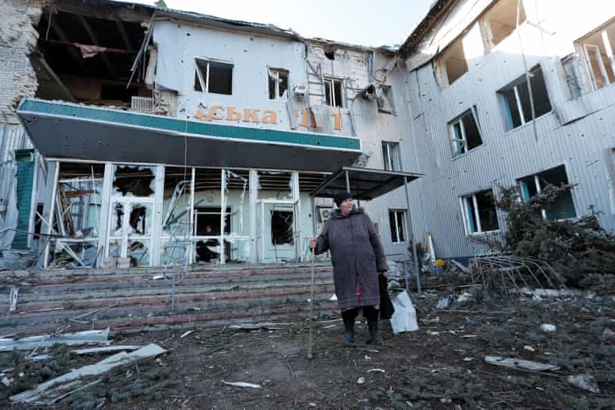 A woman stands outside a destroyed hospital in Volnovakha.