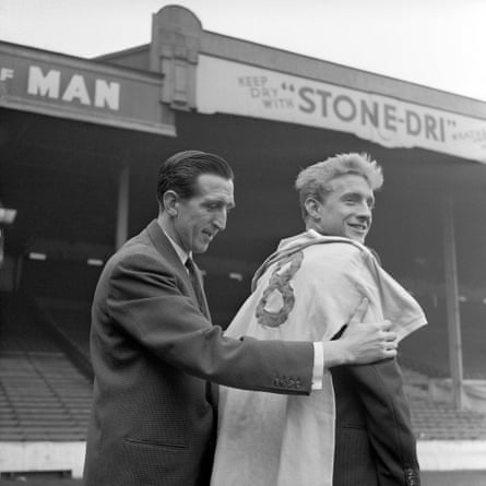 Manchester City captain Ken Barnes giving a No8 jersey to his new teammate, 20-year-old Denis Law, who has just been signed for a record fee of £45,000 to become the costliest player in English football in March 1960.