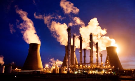 Water vapour from cooling towers and smoke from chimneys rise above Grangemouth oil refinery in Scotland during dusk