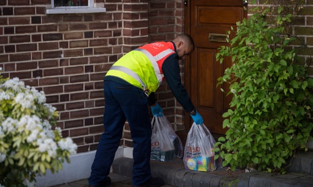 A Tesco worker delivers supplies to a vulnerable householder.