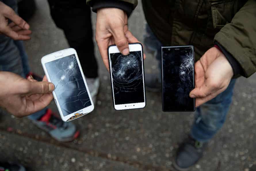 Migrants display their mobile phones that they say were destroyed by Hungarian police in Horgoš , Serbia, in January this year.