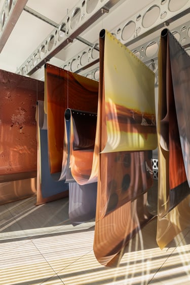 Lotus L. Kang installation: large colourful metallic sheets hang from ceiling rails in a gallery