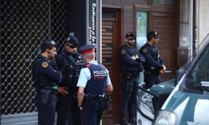 Police guard a residential building in Sabadell, north of Barcelona, after the nine arrests.