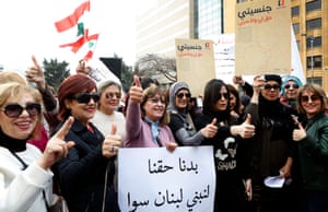Women outside the government palace in Beirut hold a banner reading in Arabic: ‘We demand our rights to build Lebanon together.’