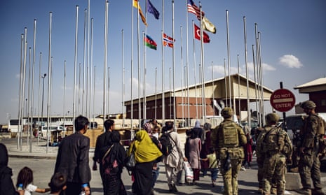 US soldiers escort a group of people to the terminal at Kabul airport