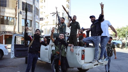 Druze fighters pose on a truck with guns raised