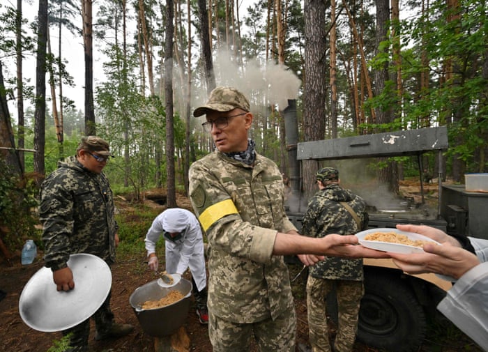 A man serves hot meals to servicemen after combat tactics classes.
