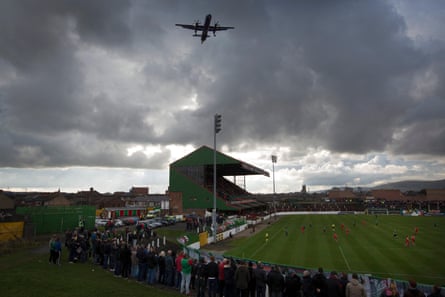 An aircraft flies over the Oval, Belfast, as Glentoran host city rivals Cliftonville in the 2016-17 season.