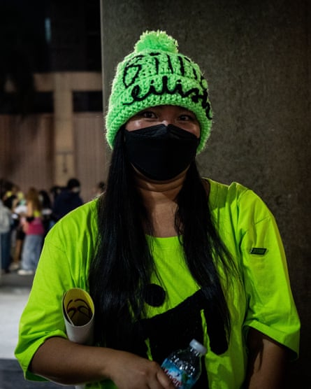 یکی از طرفداران بیلی آیلیش با کلاه و پوستری که به شوی این خواننده در بانکوک می رود.