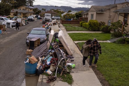 Residents walk by damaged belongings in Pajaro, California, on 29 March 2023.