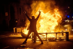 A protester poses in front of a burning barricade in Barcelona last week