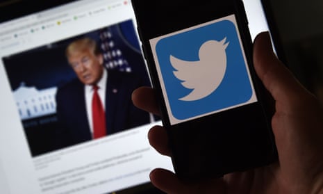 Photo illustration of a Twitter logo displayed on a mobile phone with a President Trump's picture shown in the background