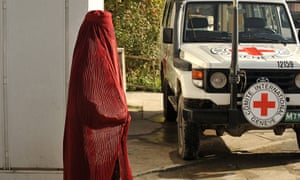 An Afghan pedestrian walks past an International Committee for the Red Cross vehicle in Kabul.