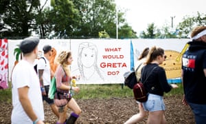 Revellers walk past a Greta Thunberg mural at Glastonbury Festival at Worthy farm in Somerset, Britain June 26, 2019. REUTERS/Henry Nicholls