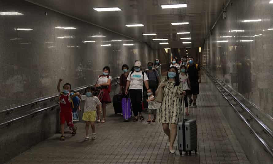 Passengers wear protective masks to guard against the spread of the coronavirus as they line up to aboard an on High-speed Railway train on 19 August 2020 in Shanghai, China.