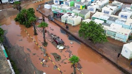 Aerial image of an overturned car on a muddy, flooded street