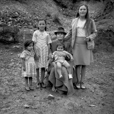 Three children, one a baby, posed with two older women
