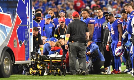 Buffalo Bills players and coaches look on in concern as Dane Jackson is treated by medical staff on the field