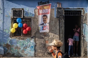 A poster supporting Nicolás Maduro is displayed outside a house with balloons strung from the windows