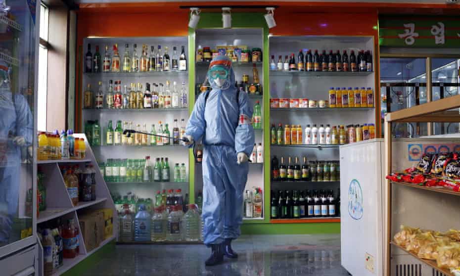 A worker disinfects a general store showroom in Pyongyang