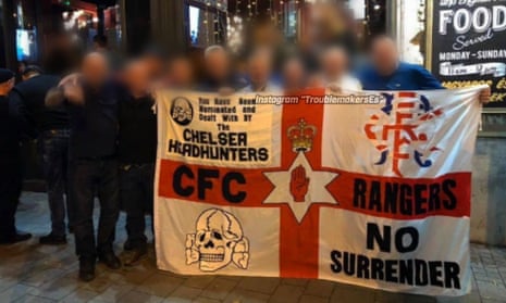 A Chelsea Headhunters flag featuring an SS Totenkopf symbol, held up outside a bar in Budapest