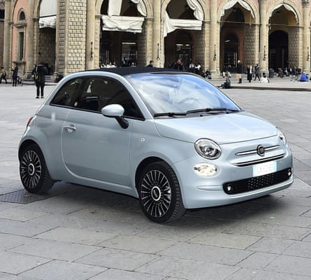 A pale Fiat 500 parked in an Italian piazza
