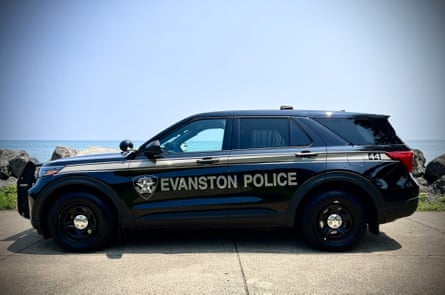 SUV marked ‘evanston police’ parked on sidewalk outside with water in the background