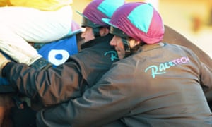 Stalls handlers urging a horse in at Lingfield Park.