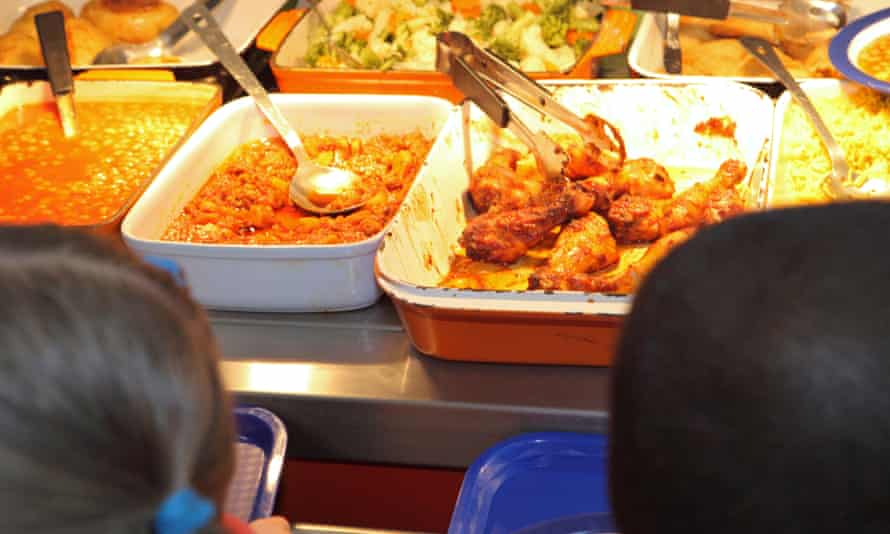 Children queuing for food in a school canteen.