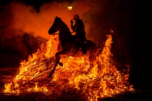 San Bartolomé de Pinares, Spain: a horse and rider jump over a bonfire in the village of San Bartolomé de Pinares in Castilla y León, during the opening of the Las Luminarias festival