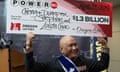 Man holds lottery check aloft at press conference