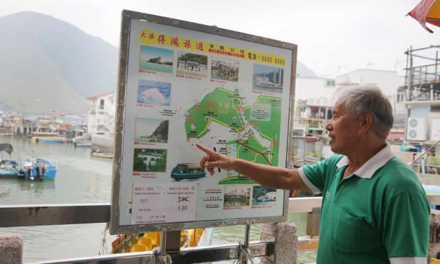 Tour boat operator Wong Yung-kan pointing out where the famous pink dolphins are found in the waters around Tai O in Hong Kong.
