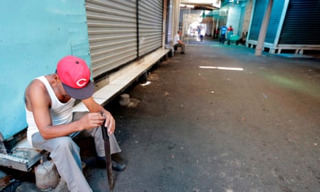 A guard sits next to closed stalls Friday in the latest nationwide 24-hour general strike in Managua, Nicaragua.