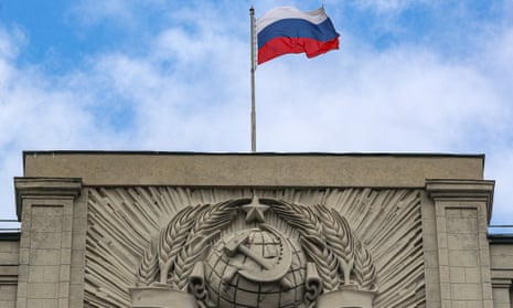 A Russian Flag flies above the coat of arms of the Soviet Union on the Russian Parliament building in Moscow.