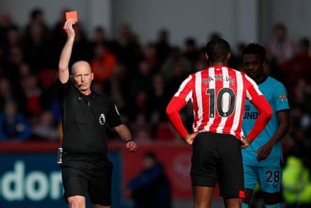 Mike Dean shows a red card to Brentford’s Josh Dasilva