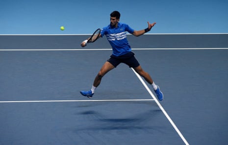 A leaping Novak Djokovic plays a backhand.