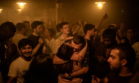 people dancing and hugging in a nightclub