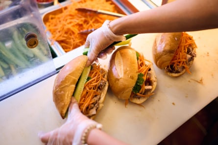 A staff member makes a bahn mi