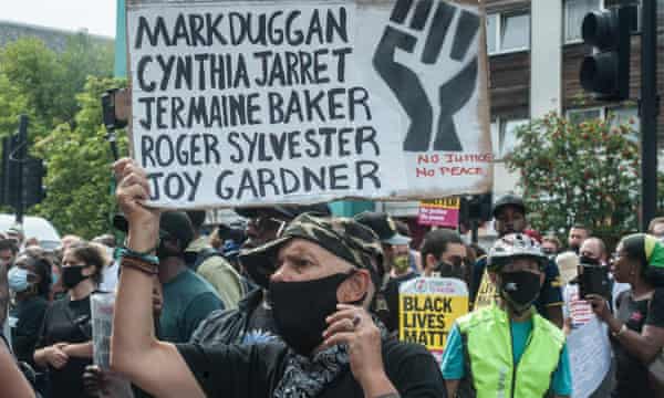 A protestor holds a sign with Mark Duggan’s name on it on the 2020 anniversary of the UK riots.