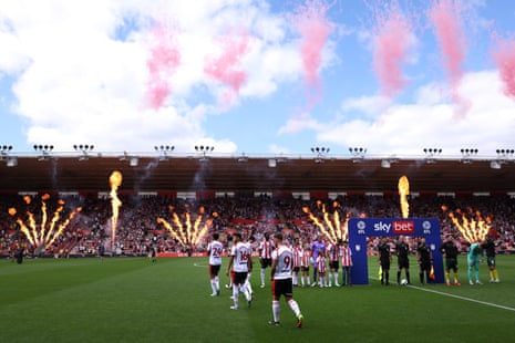 Southampton and Wrexham players walk onto the pitch as pyrotechnics are set off.